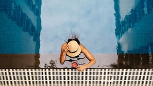 A person by a pool with a clear sky reflected in the water. - Central Mansions Hotel and Apartments (Phnom Penh)