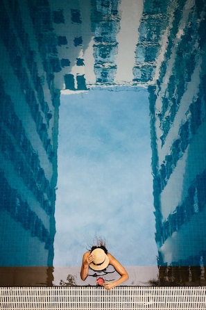 A person by a pool with a clear sky reflected in the water. - Central Mansions Hotel and Apartments (Phnom Penh)
