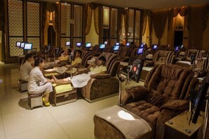 Un établissement proposant des massages, équipé de plusieurs fauteuils de massage et d’espaces de soins individuels.