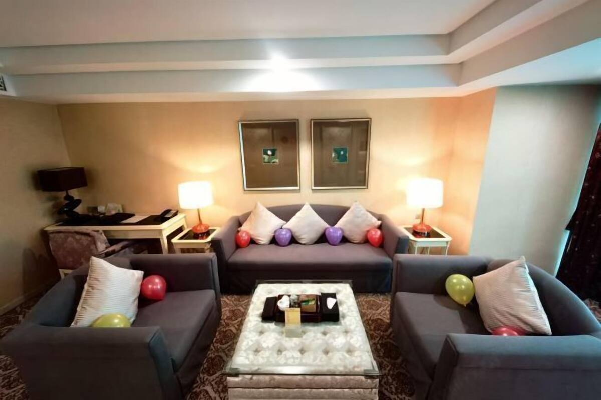 A living room with a sofa set, a coffee table, and two lamps.
