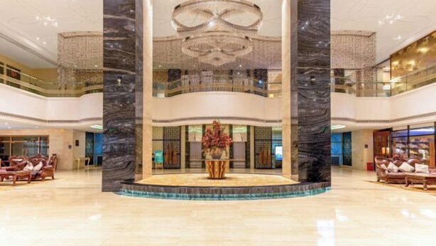 A spacious lobby with a central fountain, marble columns, and a chandelier. - Zhongshan Yihe Junli Hotel (Holiday Plaza Branch) (Zhongshan)