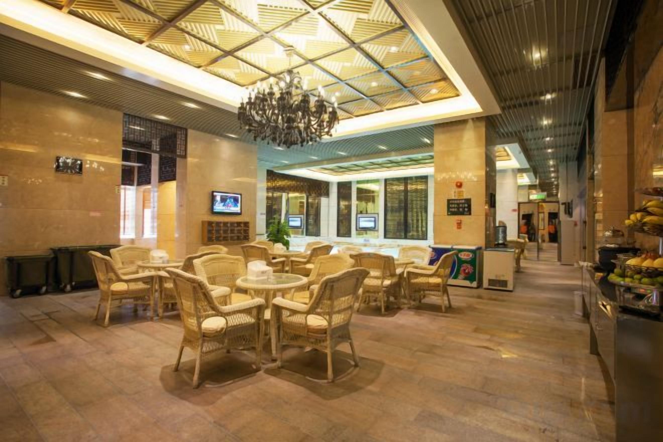 Um hall de entrada com móveis de vime, um candelabro e um balcão de recepção.