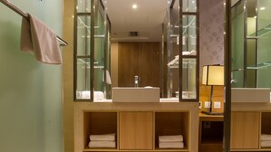 Une salle de bain moderne avec un grand miroir, deux lavabos et un porte-serviettes.