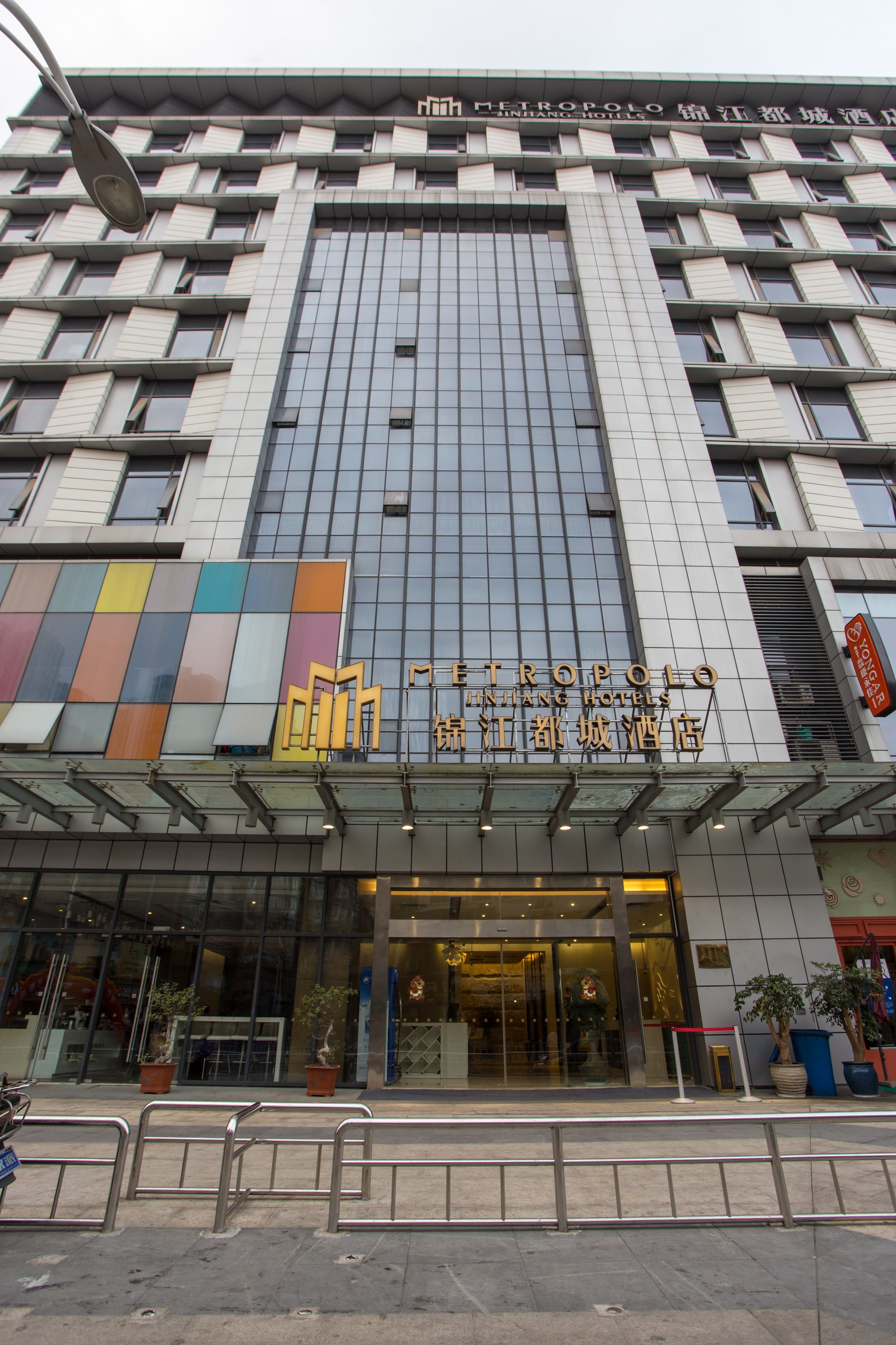 Un hôtel moderne, avec une façade en verre et une entrée imposante.