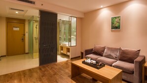 Un salon moderne avec une table basse en bois, un canapé marron et une cabine de douche en verre.