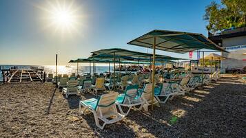 Privat strand, solstolar, parasoller och strandhanddukar