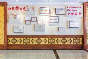 A wall with multiple framed certificates and awards. - Beizhen Hotel (Beizhen)