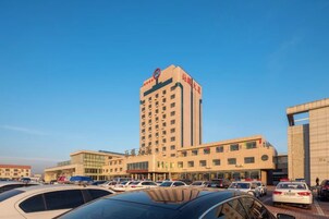 Un hotel de varios pisos con un letrero llamativo en la fachada.