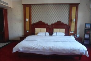 A large bed with a wooden headboard and two bedside tables.