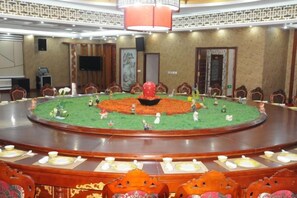 A conference room with a round table, chairs, and a decorative centerpiece. - Beizhen Hotel (Beizhen)