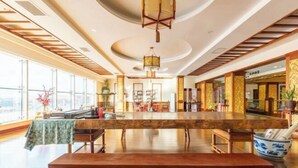 A spacious room with a long wooden table, a bench, and a traditional Asian-style lamp. - Beizhen Hotel (Beizhen)