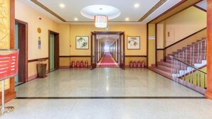 A hotel lobby with a central corridor, wooden doors, and a staircase on the right. - Beizhen Hotel (Beizhen)