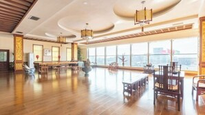A spacious room with wooden flooring, large windows, and traditional furniture. - Beizhen Hotel (Beizhen)