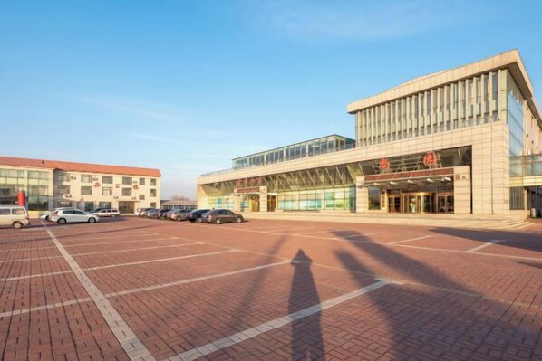 Un immeuble doté d’un grand parking et d’une entrée moderne.
