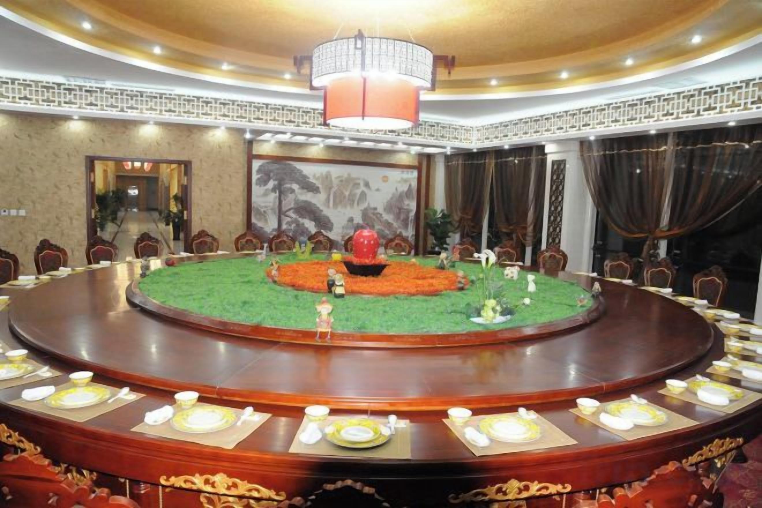 Une salle de conférence équipée d’une table ronde, de chaises et d’un lustre.