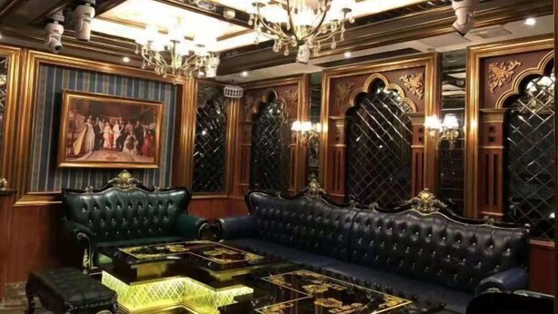 A luxurious room with a large green sofa, a matching armchair, and a coffee table with a patterned top. - Minghan Holiday Hotel (Zhuhai Doumen Xinqing Science and Technology Park) (Zhuhai)