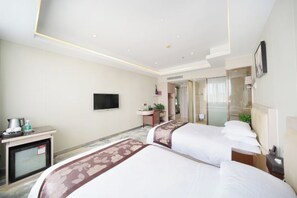 A hotel room with two beds, a desk with a coffee maker, a TV mounted on the wall, and a bathroom visible through a glass door. - Minghan Holiday Hotel (Zhuhai Doumen Xinqing Science and Technology Park) (Zhuhai)