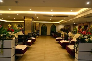 A hotel room with a long corridor, seating area with chairs, and potted plants. - Minghan Holiday Hotel (Zhuhai Doumen Xinqing Science and Technology Park) (Zhuhai)