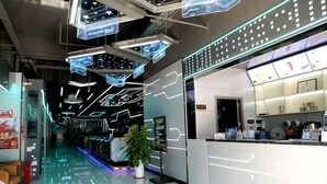 A modern hotel lobby with a digital display wall, a reception desk, and a seating area. - Minghan Holiday Hotel (Zhuhai Doumen Xinqing Science and Technology Park) (Zhuhai)