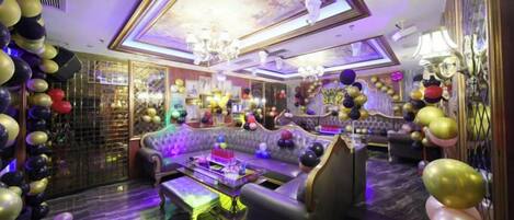 A luxurious lounge area with a plush sofa, a bar area, and a chandelier.