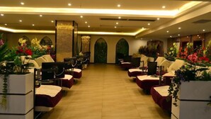 A hotel lobby with rows of seating, a central decorative wall, and a ceiling with recessed lighting. - Minghan Holiday Hotel (Zhuhai Doumen Xinqing Science and Technology Park) (Zhuhai)