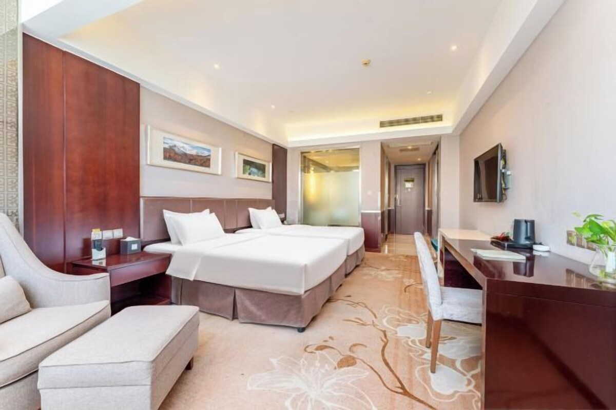 Een hotelkamer met een groot bed, een bureau, een stoel en een sofa.