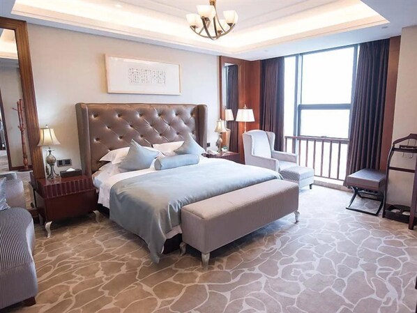 A hotel room with a large bed, a sitting area, a desk, and a view of the outdoors. - Zhonglang Holiday Hotel (Nanjing)