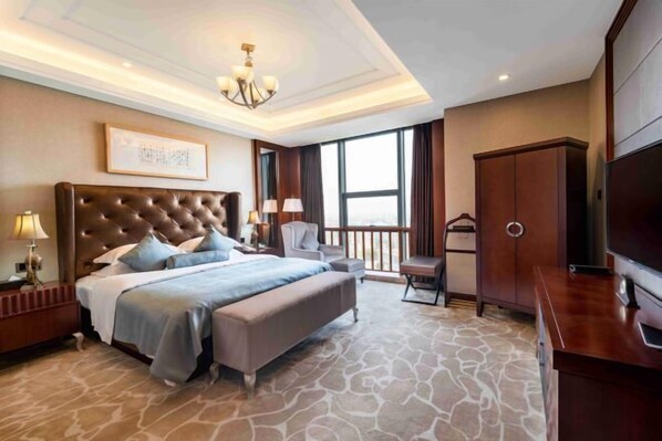 Un dormitorio amplio con una cama grande, un televisor y un armario.
