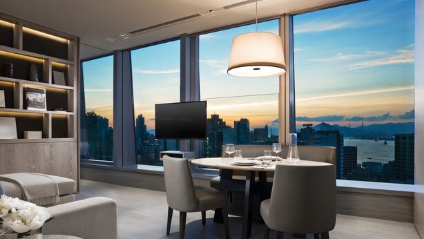 A modern dining area with a city view, a flat-screen TV, and a large window. - One96 (Hong Kong)