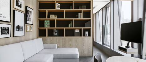 A modern living room with a white sectional sofa, a wooden bookshelf, and a large window with a city view.