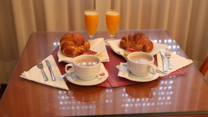 A breakfast table with croissants, coffee, and orange juice. - Motel Aeropuerto (Mos)