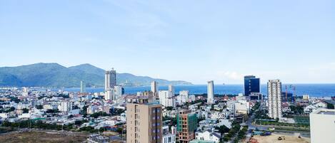 Un paisaje urbano con vista al mar y montañas al fondo.