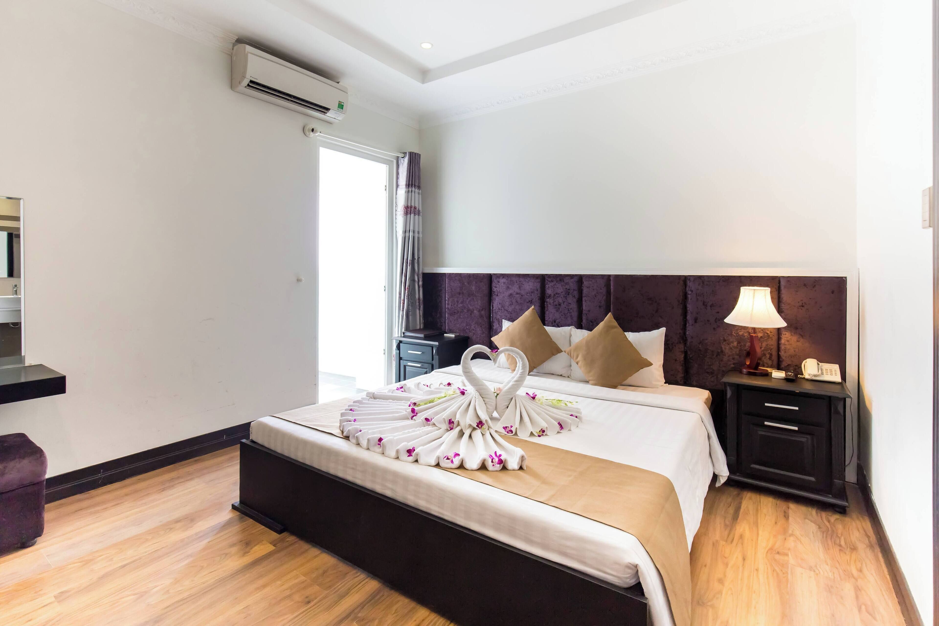 Une chambre d’hôtel équipée d’un lit, d’une table de chevet, d’une lampe et d’un appareil de climatisation.