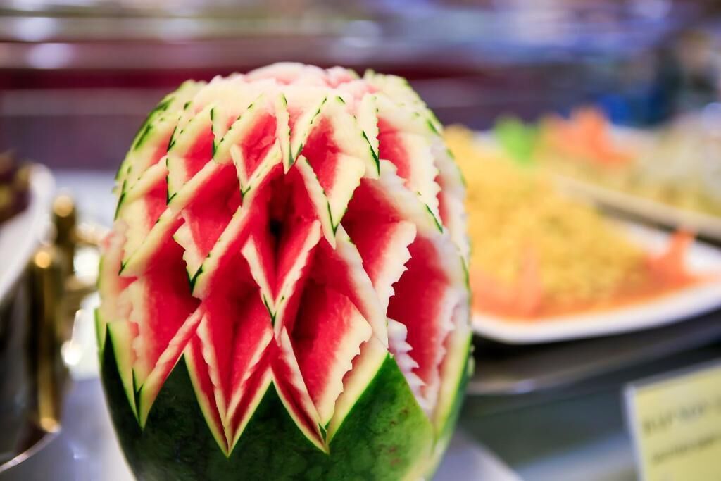 A watermelon with a decorative pattern carved into its rind.