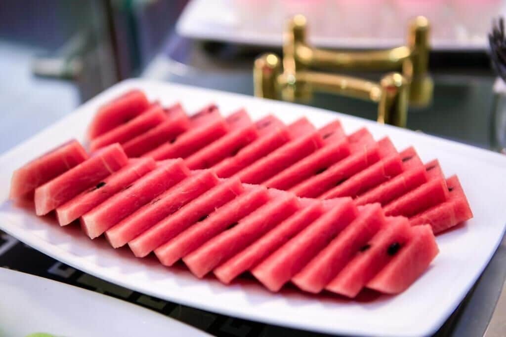 Eine Schale Wassermelonenscheiben, kunstvoll zu einem Fächer geformt.
