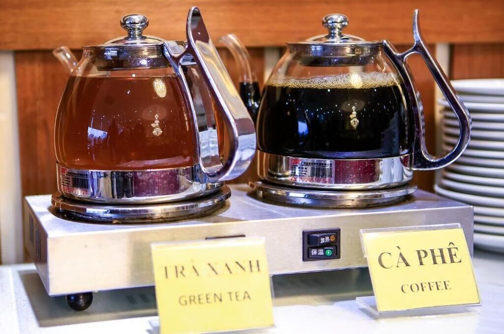 Two glass carafes labeled "Green Tea" and "Coffee" on a display stand.