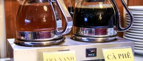 Dos jarrones de vidrio etiquetados como "Té verde" y "Café" sobre un expositor.