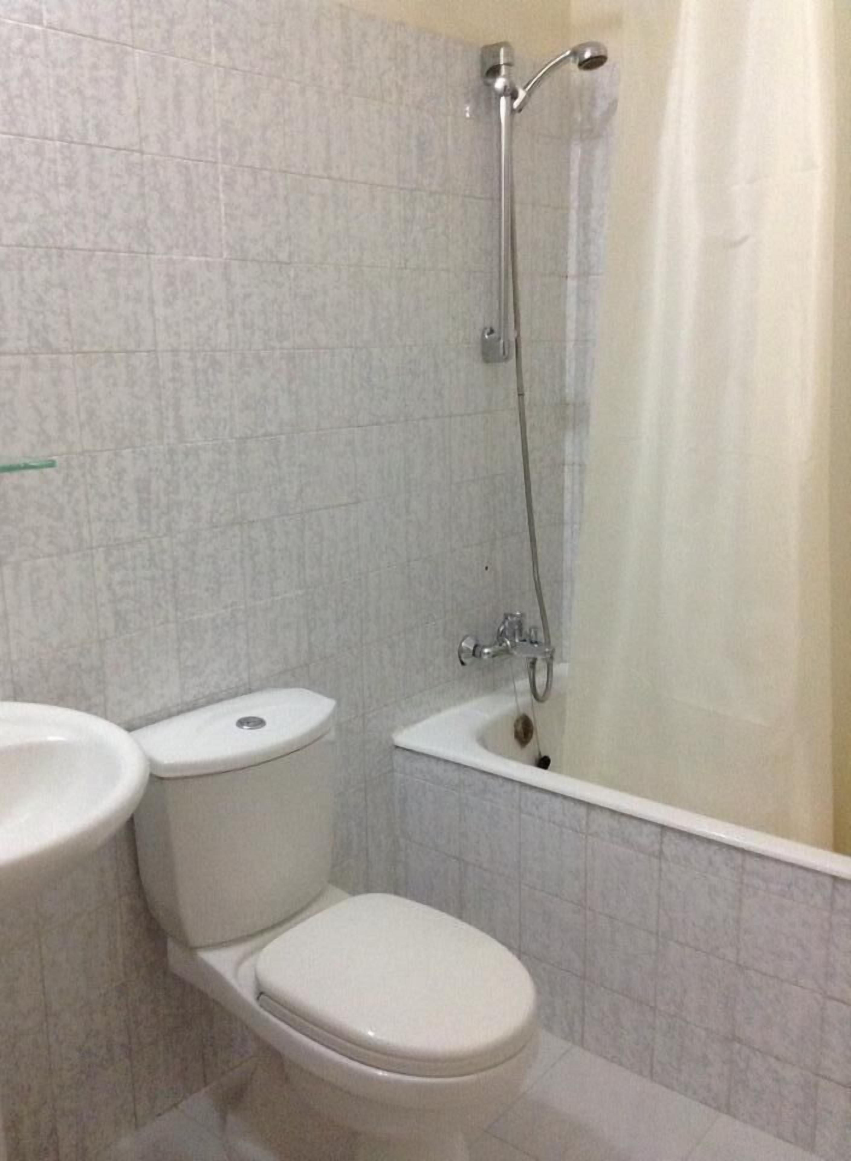 Een badkamer met toilet, wastafel en bad.