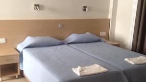 A hotel room with a large bed, two bedside tables, and a wooden chair. - Christabelle Hotel Apartments (Ayia Napa)