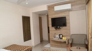 Une chambre d’hôtel avec deux lits, une télévision, une petite table et une chaise.