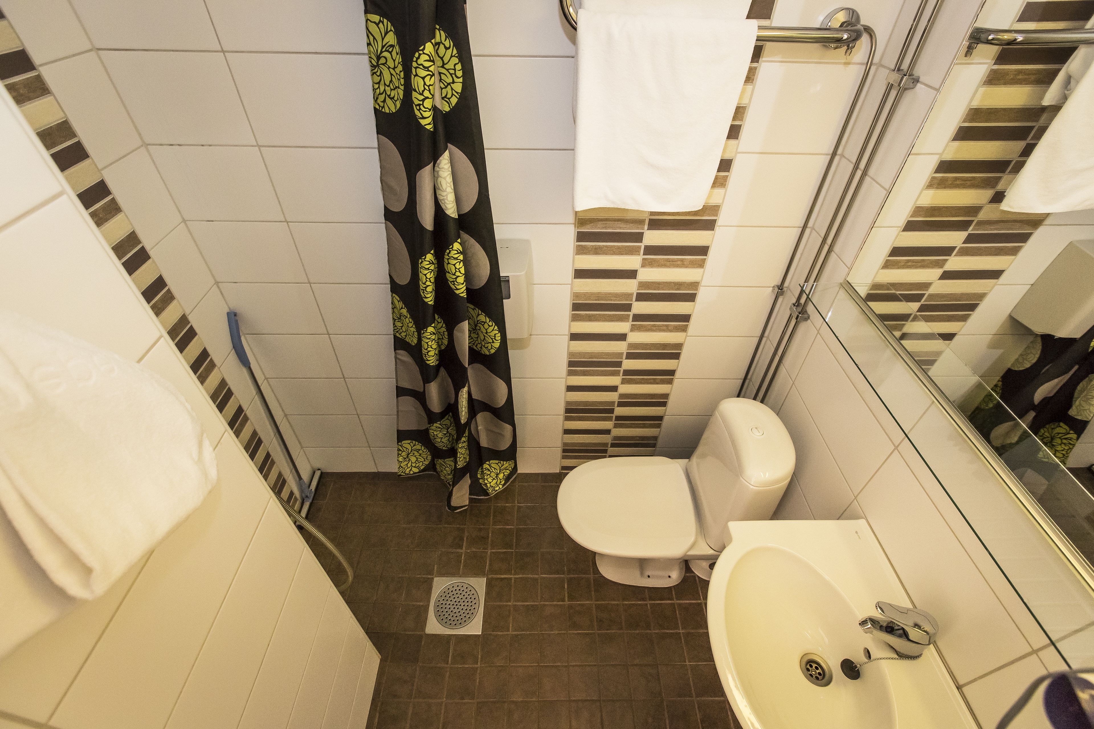 Une salle de bain comprenant des toilettes, un lavabo et un espace douche.