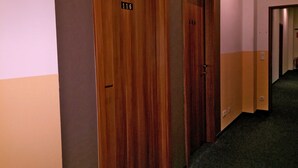 Un couloir avec des portes en bois, chacune portant un numéro.