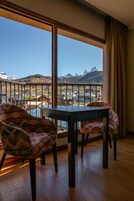 Un balcón con mesa y sillas, con vistas a un paisaje montañoso.