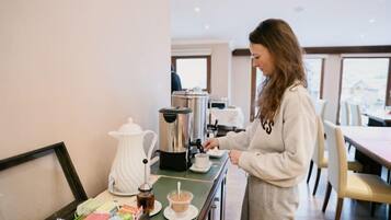 A person preparing coffee in a modern kitchen with a view of the city.