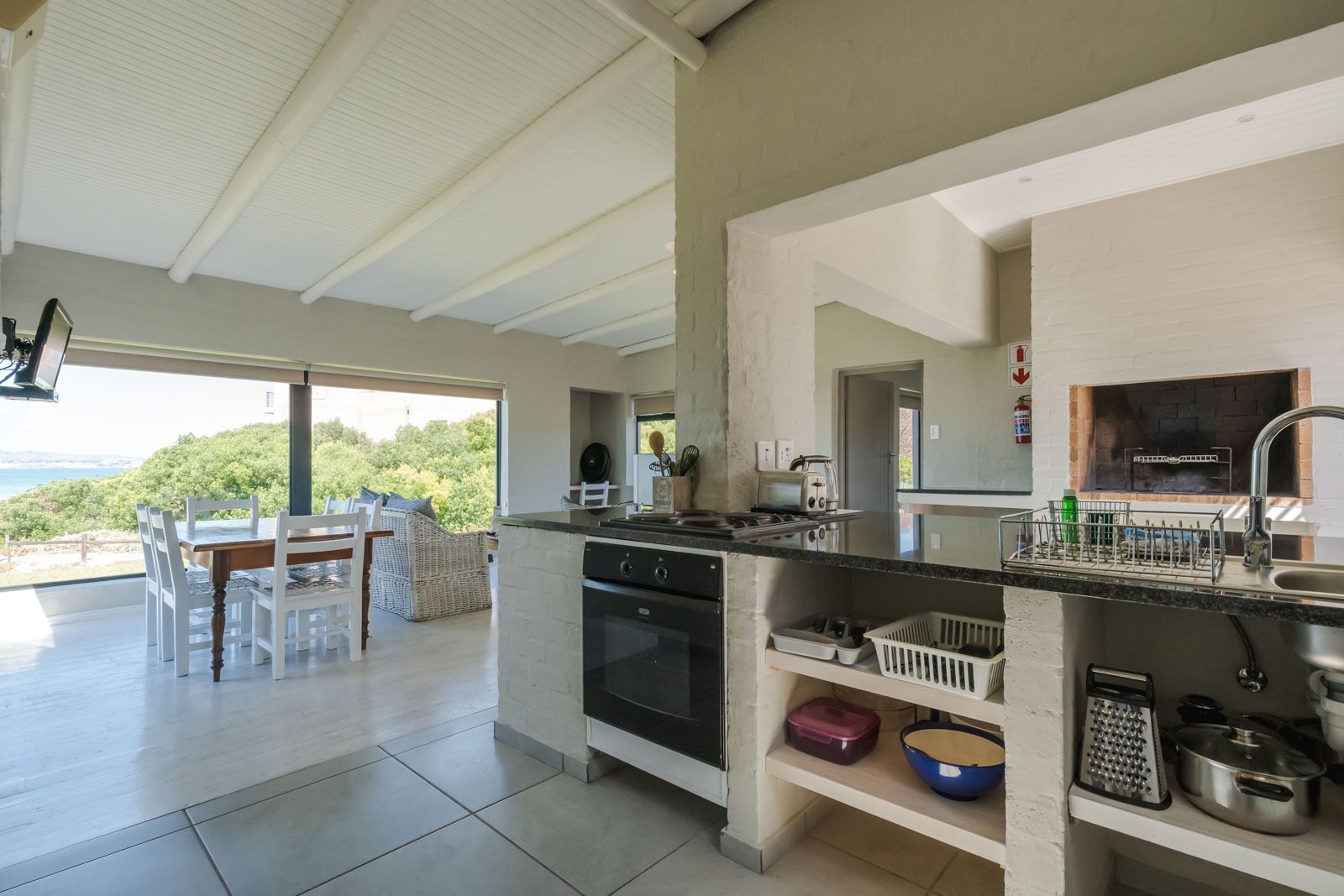 Cocina moderna con una isla grande, horno empotrado y vistas al mar.