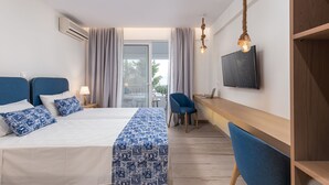 Een hotelkamer met een bed, een bureau, een stoel, een televisie en een raam met gordijnen.