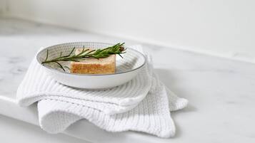 Un tessuto bianco e strutturato su una superficie di marmo bianco.
