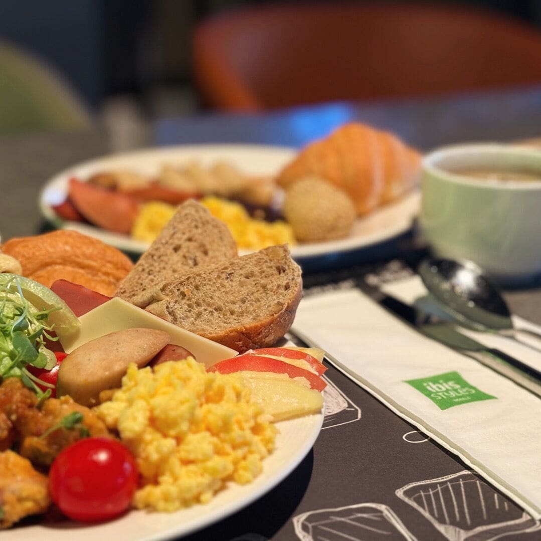 Desayuno con platos de huevos, tostadas y fruta.