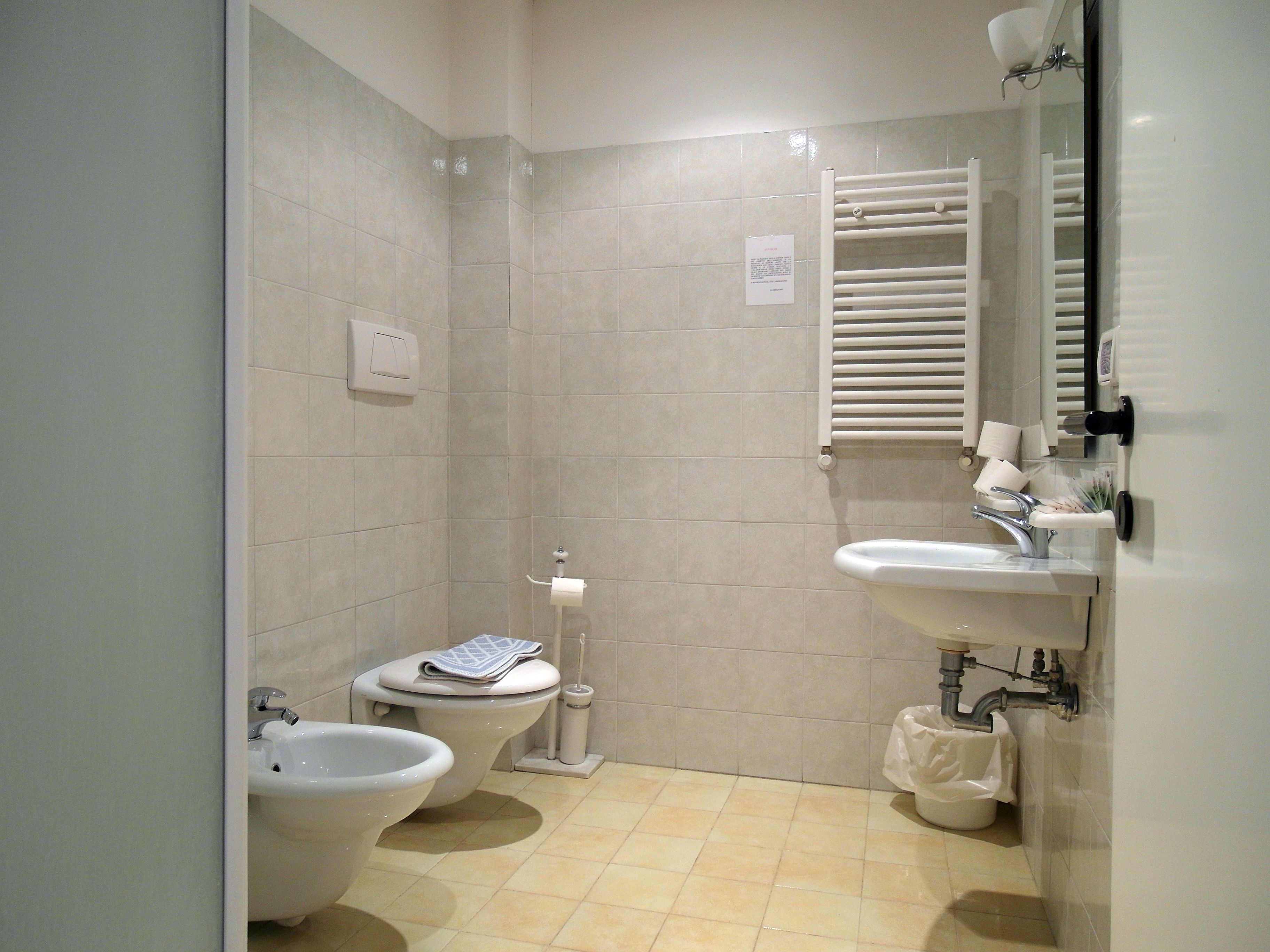 A bathroom with a toilet, bidet, and sink.