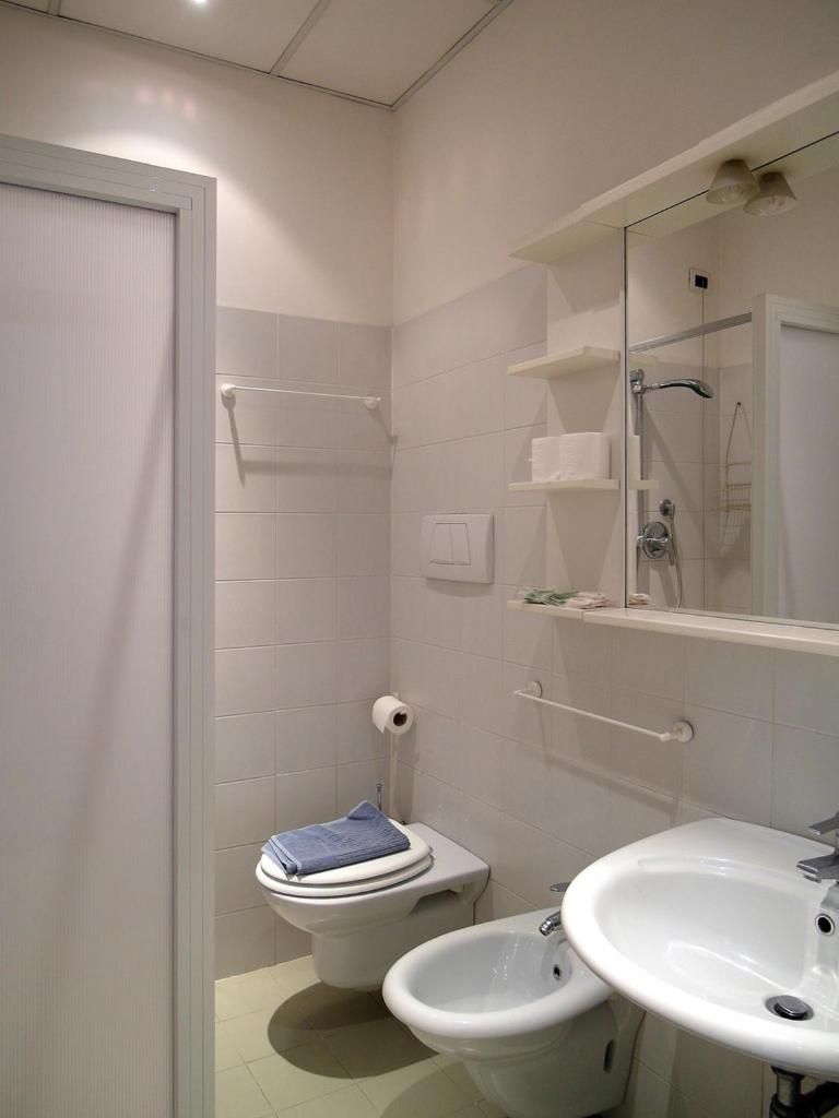 A small bathroom with a toilet, bidet, and sink.